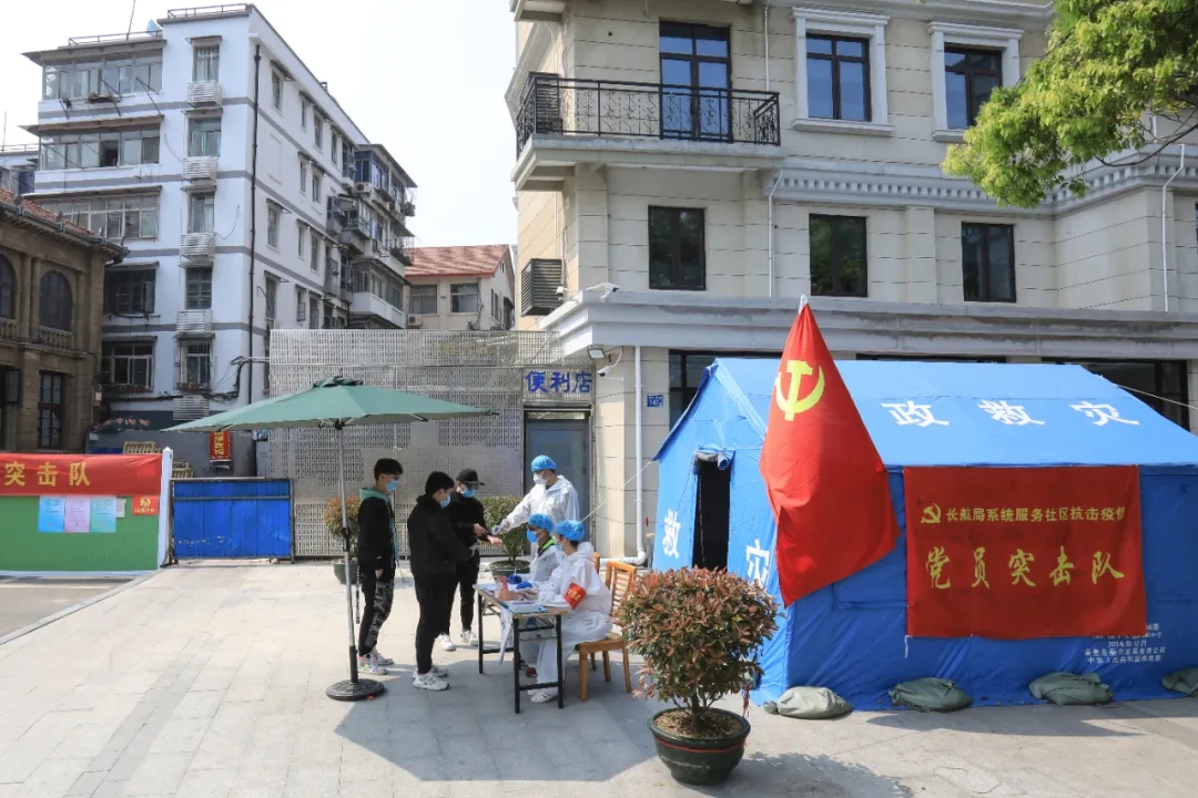 黨員突擊隊在小區(qū)防控點為出入群眾測量體溫，記錄信息。